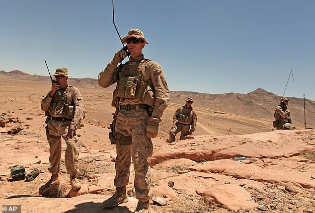 Three US soldiers were killed in a suicide drone attack on a US base in Jordan, US Central Command said on Sunday.  Pictured: Marines talk to their comrades on the ground during military maneuvers in the Middle East, which borders Syria and Iraq