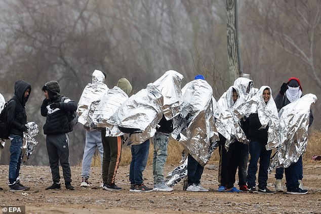 Migrants line up as they prepare to be picked up by Border Patrol agents in Eagle Pass, Texas