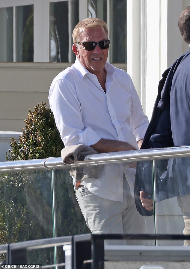 Wearing designer sunglasses, Kevin dressed his slim 6-foot-2 frame in a classic white button-up shirt, off-white jeans and black flip-flops.