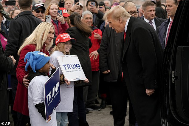 Republican presidential candidate, former President Donald Trump, right, and Rep. Marjorie Taylor Greene, R-Ga., left, greet young supporters during a campaign stop in Londonderry