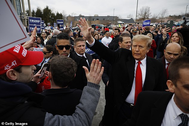 Donald Trump greets a voter during his stop in Londonberry, NH