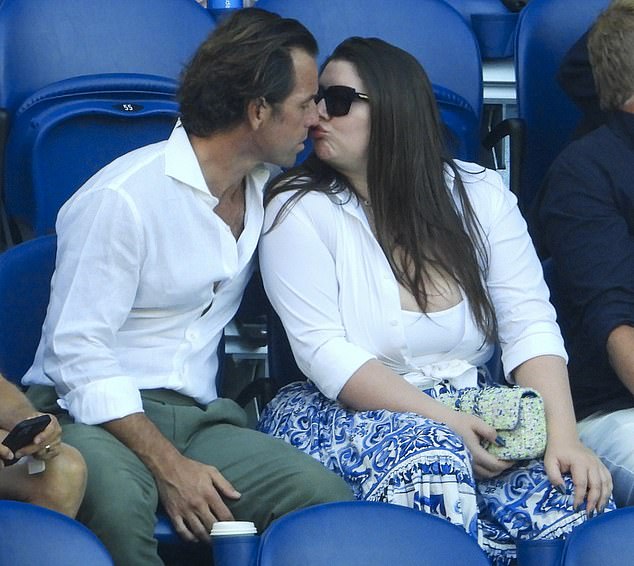 When they arrived at their seats, the lovebirds could not resist a tender moment by sharing a sweet kiss