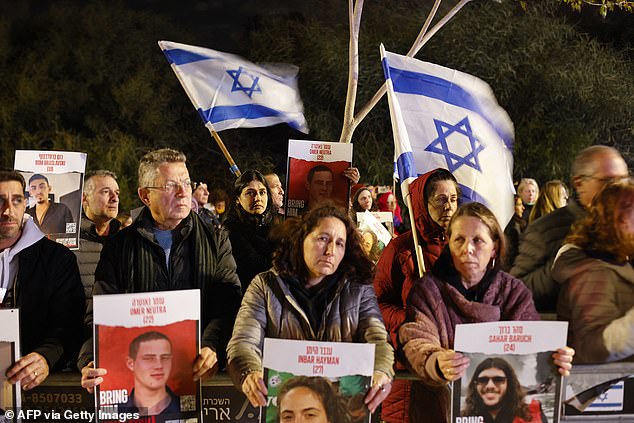 About 136 people are still missing after being kidnapped and held hostage in Gaza following the attack by Hamas on October 7 last year.  Protesters are pictured raising national flags and portraits of Israelis held hostage by Palestinian Hamas militants in Gaza since October 7, during a rally demanding their release outside the private home of Israeli Prime Minister Benjamin Netanyahu.