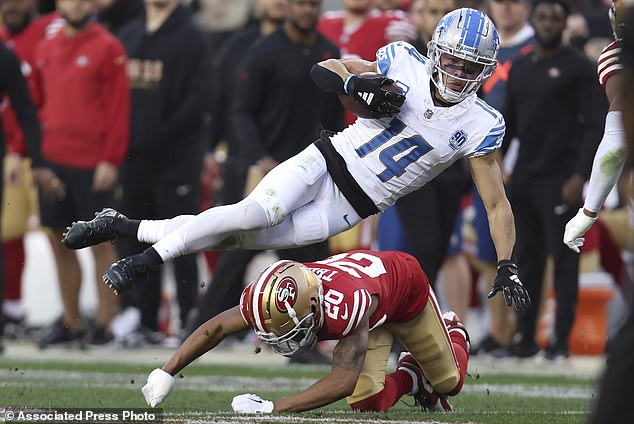 Lions WR Amon-Ra St. Brown tries to jump over 49ers cornerback Ambry Thomas