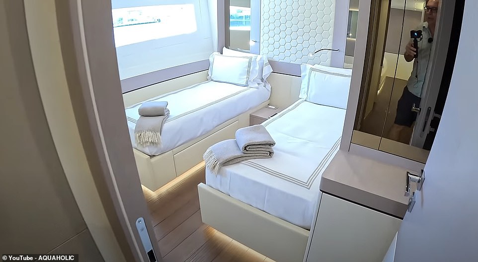 Nick goes to the lower deck and shows the other cabins.  One cabin has two single beds with a fold-out bed on one side, creating a bunk bed.  An adjacent cabin has an almost identical configuration