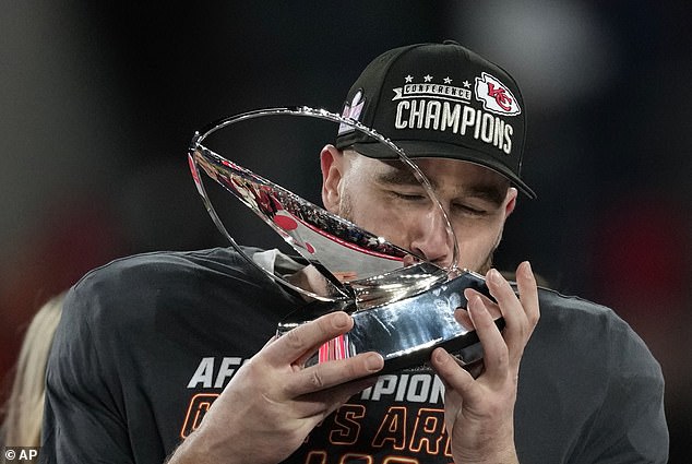 Kelce kisses the Lamar Hunt trophy as he commemorates a stunning victory for the Chiefs