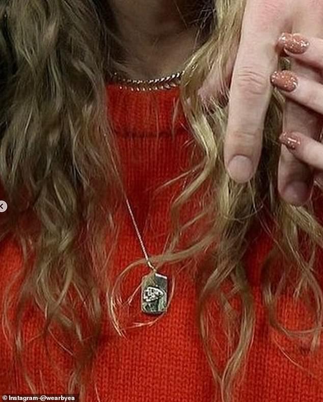 A close-up of her Chiefs necklace shows the team's logo engraved on the jewelry