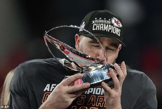 Kelce kisses the Lamar Hunt trophy as he commemorates a stunning win for the Chiefs