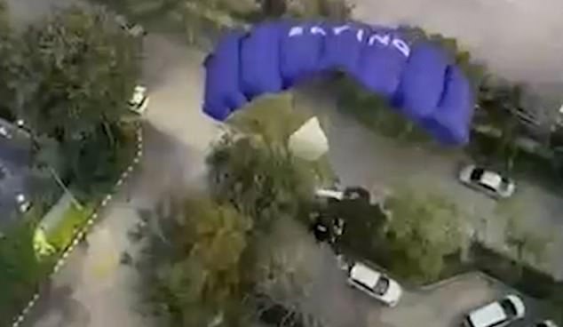 In the video, Nathy can be seen balancing on a narrow ledge before jumping off, his parachute immediately deploying (pictured)