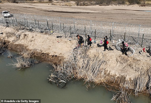 An aerial view of the area as migrants walk past barbed wire after crossing the Rio Grande into the United States on January 28, 2024