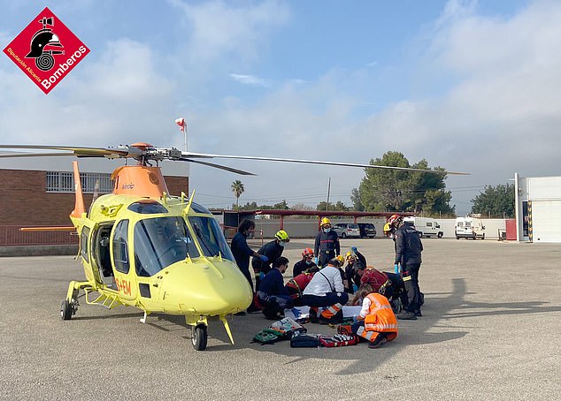 Emergency workers next to the trauma helicopter providing assistance to the 80-year-old climber