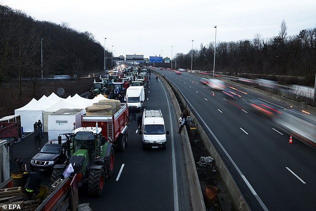 Dozens of tractors behind some tents to spend the night on the A-15 highway near Argenteuil, north of Paris