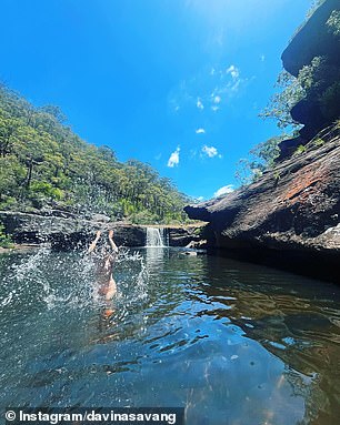 The water flows along a rocky edge to the pool below, which is lined with smooth boulders, giving travelers plenty of places to relax