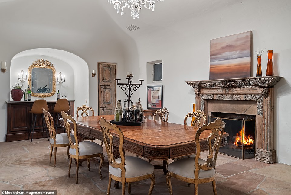 The main residence's dining room is flooded with natural light thanks to the floor-to-ceiling windows, creating an ethereal luminescence across the stone floor