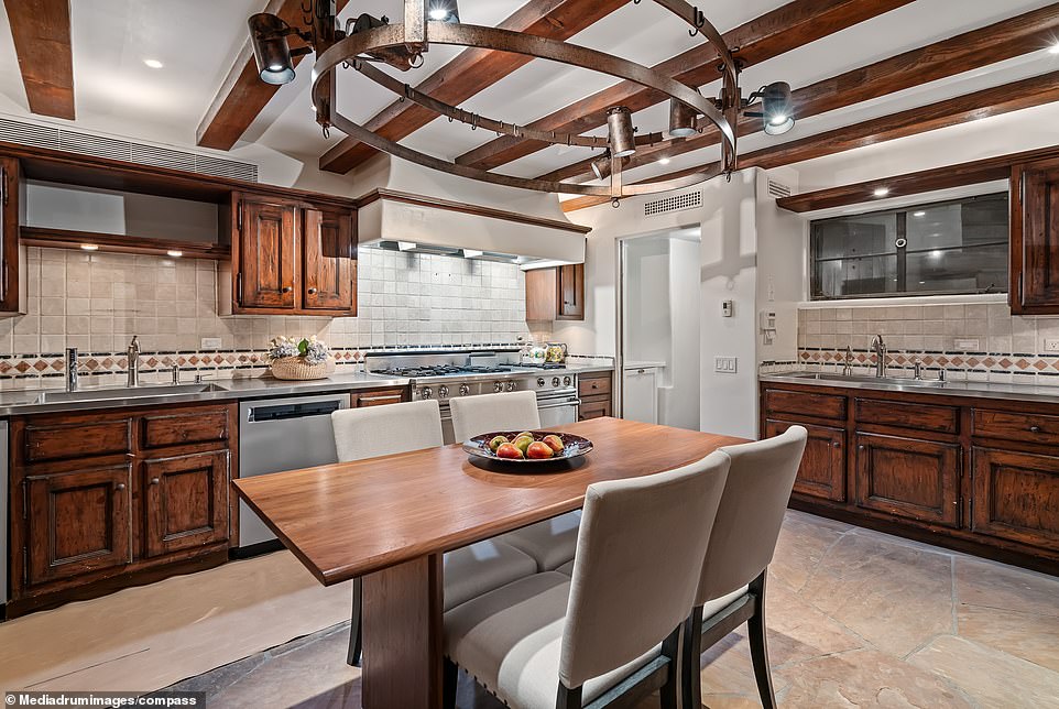 The chef's kitchen with its rustic oak doors and storage cupboards, along with a double door oven, provides the perfect place to prepare a feast