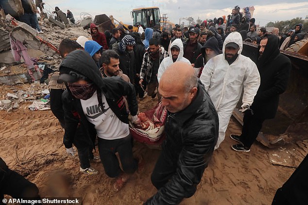 Residents and civil protection teams carry out a search and rescue operation around the rubble of a building demolished on January 29 after an Israeli attack in El-Zawaida, Gaza.