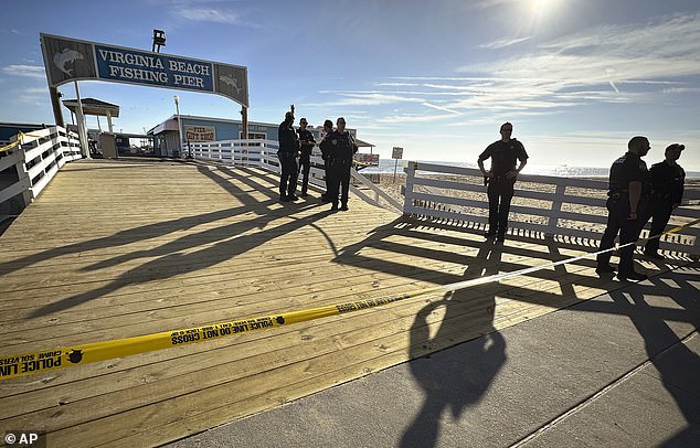 Police investigate the scene at the Virginia Beach Fishing Pier where a car drove through a gate on the pier around dawn in Virginia Beach early Saturday