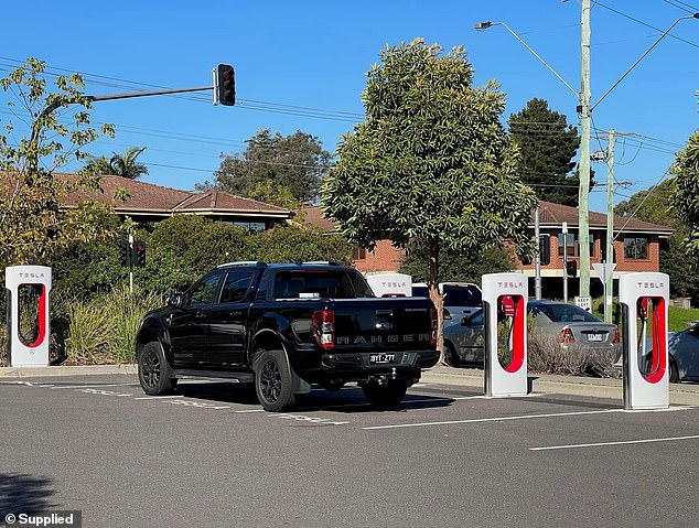 Motorists who park their petrol and diesel cars in areas specifically designated for electric cars (stock image of a car parked in an EV charging area) are facing hefty fines in several Australian states and territories