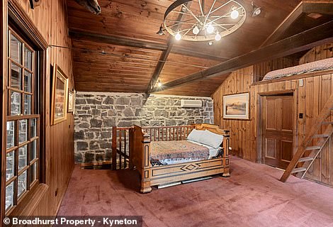 A gray stone coach house is decorated inside with rich wood and houses a billiards room, a lounge, a sitting room, a bedroom and two small bathrooms, one of which has a luxurious freestanding bath.