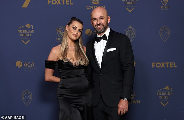 The cricket WAG hopped on the arm of her husband Nathan, wearing a stunning off-the-shoulder black satin dress