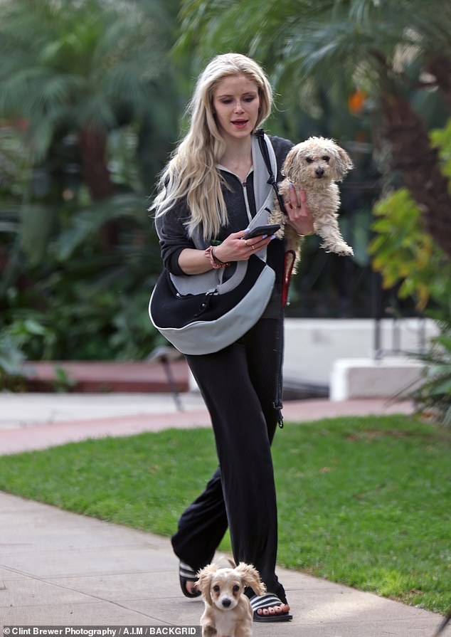 For her relaxed outing, the artist, who wore a blue manicure, wore a charcoal gray and white zip-up hoodie, black leggings and a pair of striped slides.