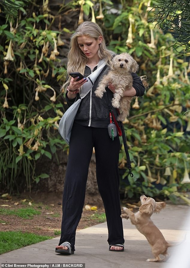 She also wore a dog sling, but chose to carry one of her puppies while the other walked around loose on a leash at her side