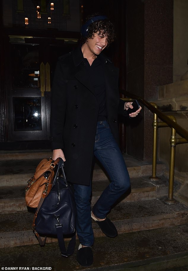 Bobby wore a nice black coat and headphones as she headed out in the rainy conditions