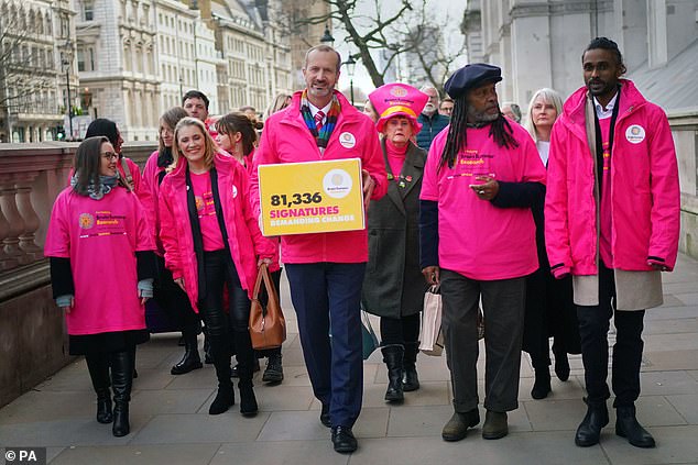 Brain tumor campaigners, including Antiques Roadshow expert Theo Burrell and campaigner Laura Nuttall's mother, Nicola Nuttall, walk along Whitehall on their way to Downing Street