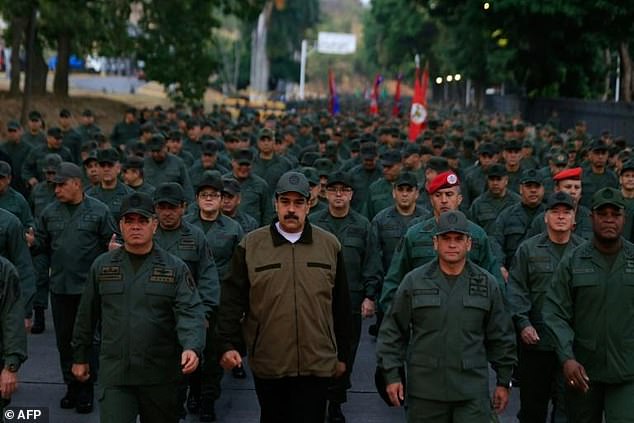 This Venezuelan government handout photo shows President Nicolas Maduro (C) marching with soldiers and military personnel in 2019.  The new study will show how citizens demand a leader who abandons the basic principles of democracy – if that means protection and security