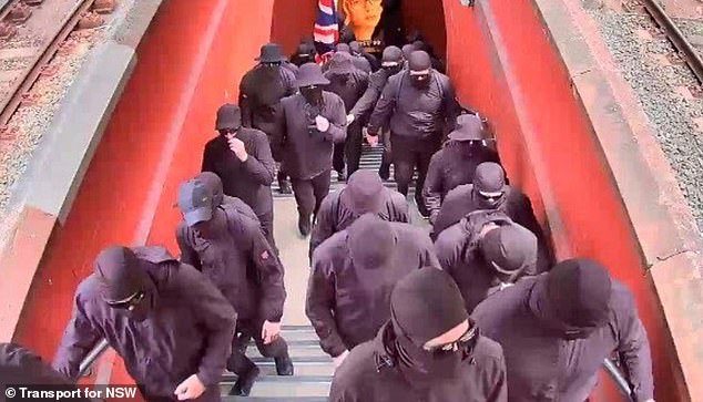 SW Prime Minister Chris Minns has condemned a balaclava-clad neo-Nazi group (pictured) who were taken from a Sydney train station on Australia Day