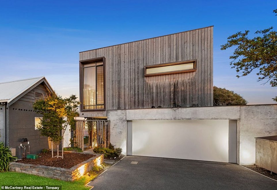 A modern wood and concrete structure conceals a seaside oasis packed with luxury amenities, including a rooftop terrace, wine cellar and an epic backyard with a pool, trampoline and jungle gym