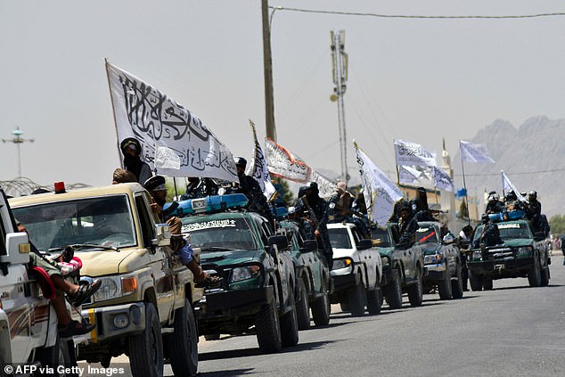 Taliban fighters atop vehicles flying Taliban flags parade along a road to celebrate the US withdrawal of all its troops from Afghanistan, in Kandahar on September 1, 2021 following the Taliban's military takeover of the country