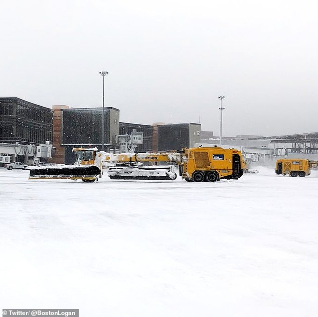 A photo shared by Boston Logan International Airport shows crews clearing snow.  The airport warned passengers to expect weather-related cancellations and delays