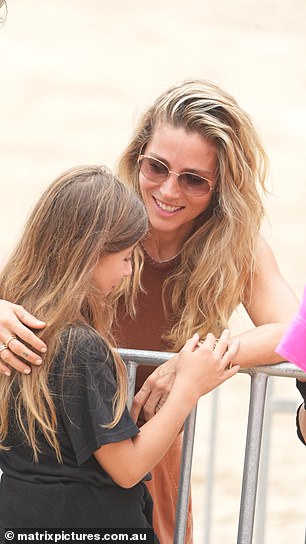 Elsa, ever the loving mother, hugged her daughter India Rose on the sand