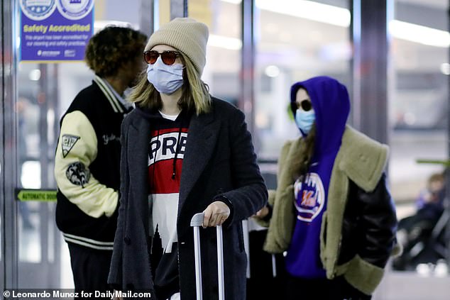 Flying under the radar: Cara Delevingne was spotted landing in New York City with her girlfriend Minke on New Year's Day as she tried to keep a low profile