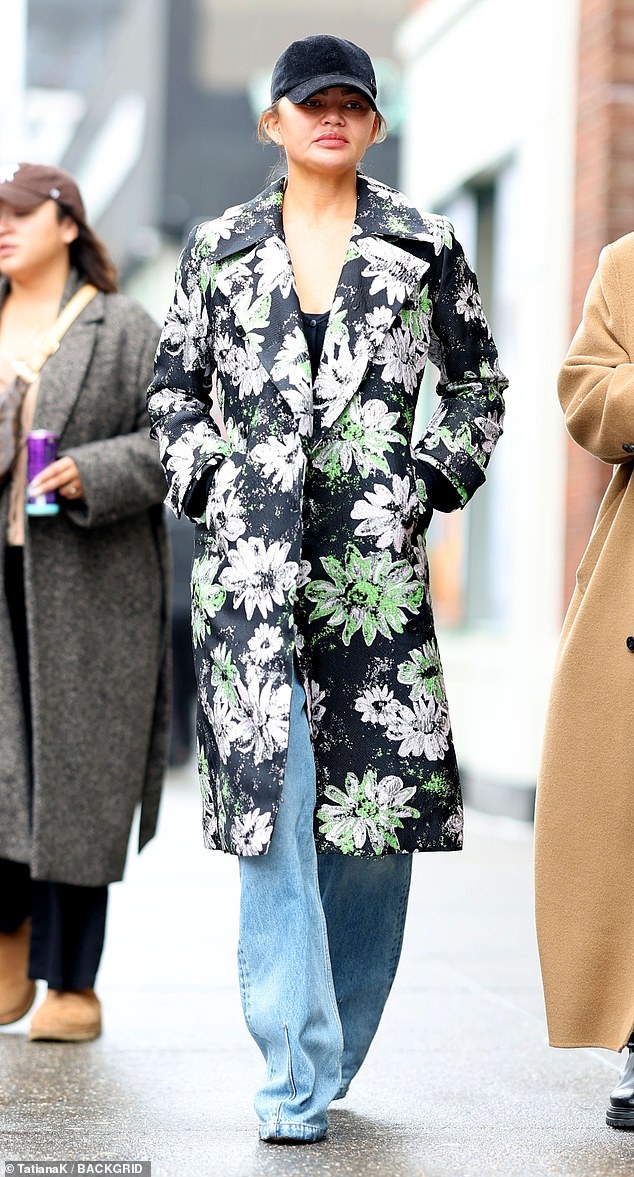 The 38-year-old kitchen connoisseur wore a fitted, cropped black top under a black raincoat decorated with a white-green floral pattern