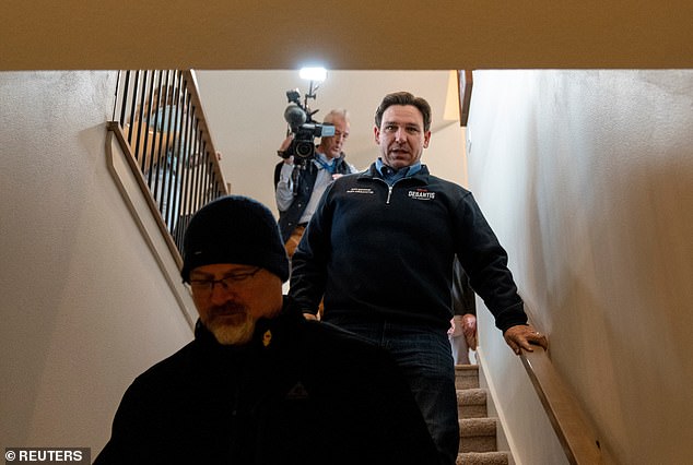 Republican presidential candidate Ron DeSantis walks down the stairs as he visits residents of a private home in Iowa