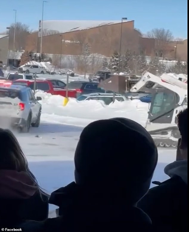 The driver of a loader lowered his shovel to window height before charging at the police car.  Images have been posted online of the disaster in a housing depot parking lot in Nebraska