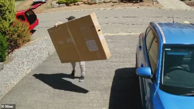 A security camera in her garage captured the man walking into her driveway with the box