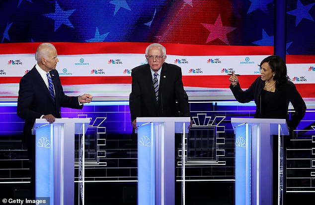 Kamala Harris and President Joe Biden speak as Senator Bernie Sanders looks on during the second night of the first Democratic presidential debate on June 27, 2019 in Miami, Florida