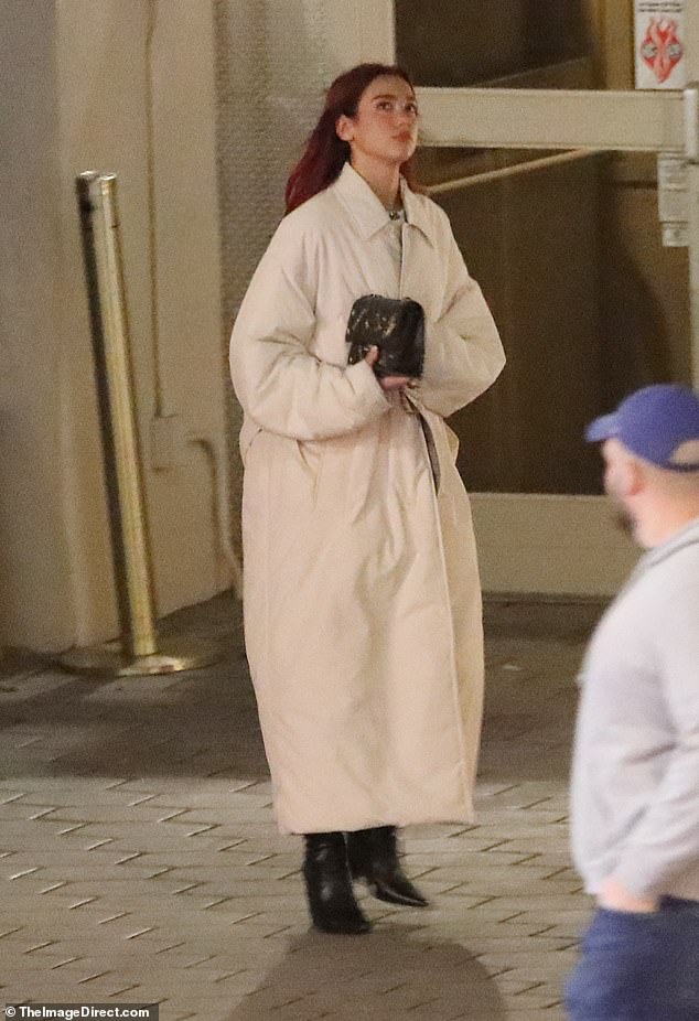 Dua Lipa wore a long white coat as she left the Sunset Tower Hotel on the Sunset Strip in West Hollywood on Friday
