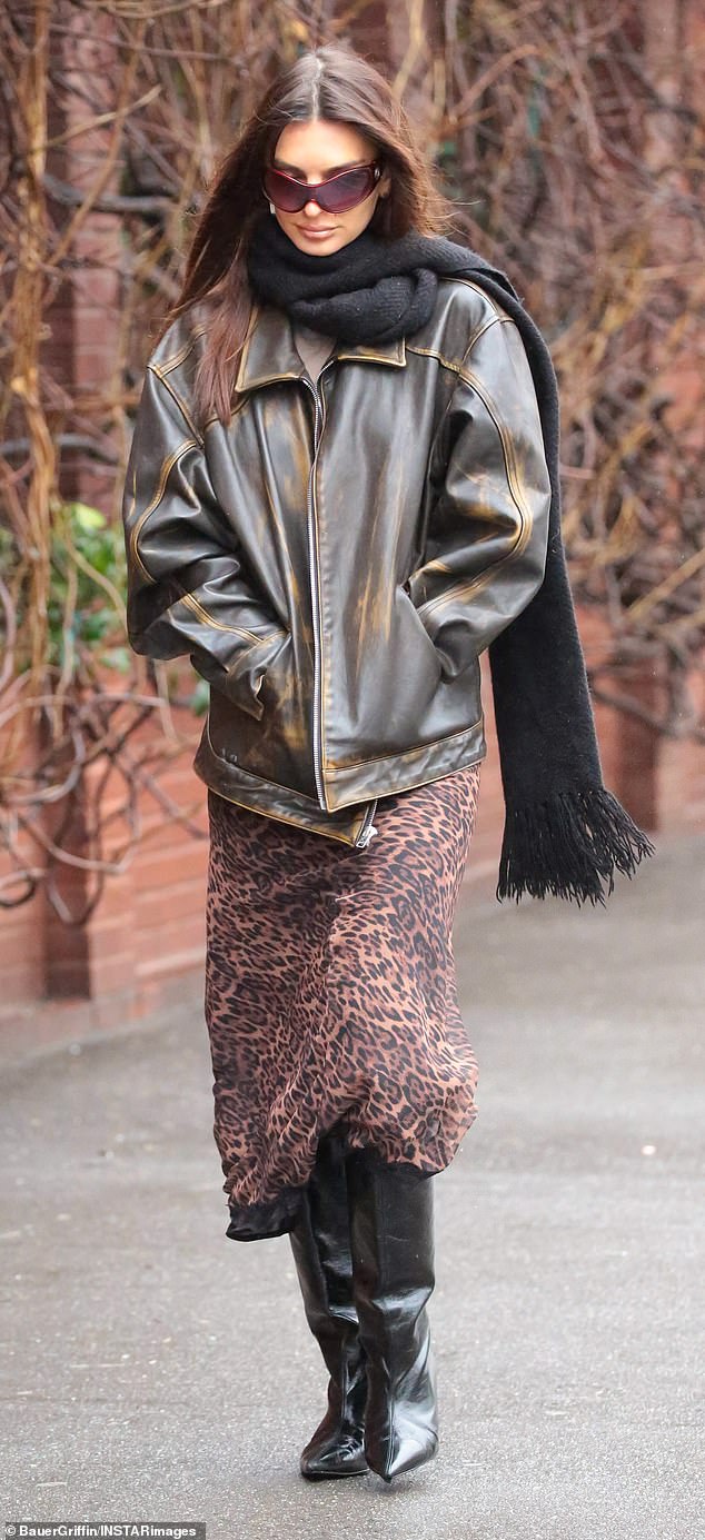 The model, 32, wrapped in an oversized leather jacket for warmth, which she wore over a leopard print midi skirt