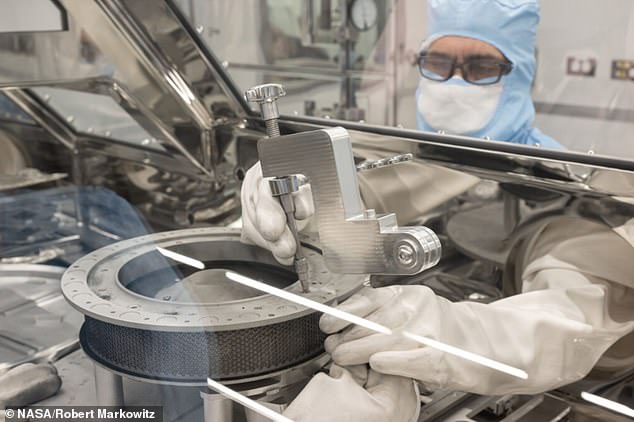 NASA engineer Neftali Hernandez uses one of the tools developed to remove two final fasteners that prevented the complete disassembly of the TAGSAM (Touch-and-Go Sample Acquisition Mechanism) head that contains the rest of the material recovered from Bennu collected in the OSIRIS-REx sapce capsule