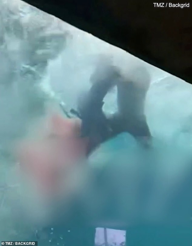 As the boy tries to fight his way to safety, sharks can be seen circling the tank in a frenzy