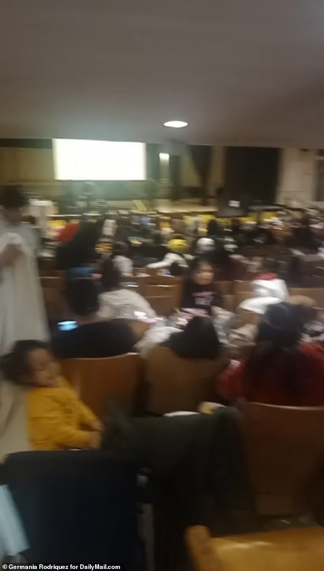 Shocking footage has shown hundreds of asylum seekers sleeping on the floor of a Brooklyn school auditorium after children were kicked out of classes so 2,000 migrants could move in.