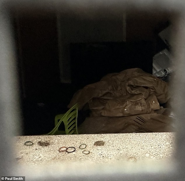 Images through corrugated iron show a green plastic highchair and toys in one of the rooms, while in another room a sofa is wrapped in clear plastic with a Police Scotland sticker on it.