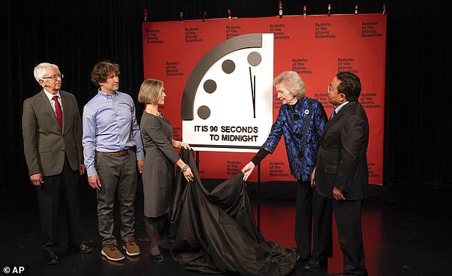 Experts from the Bulletin of the Atomic Scientists remove a cloth covering the Doomsday Clock in Washington on January 24, 2023.  ​​Last year the clock went forward to 90 seconds before midnight.  It was the closest the Doomsday Clock came to midnight in its entire history