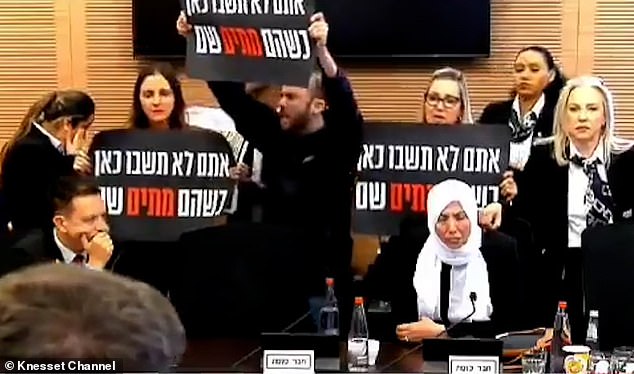 Protesters held up signs and chanted slogans during a Knesset parliamentary session yesterday