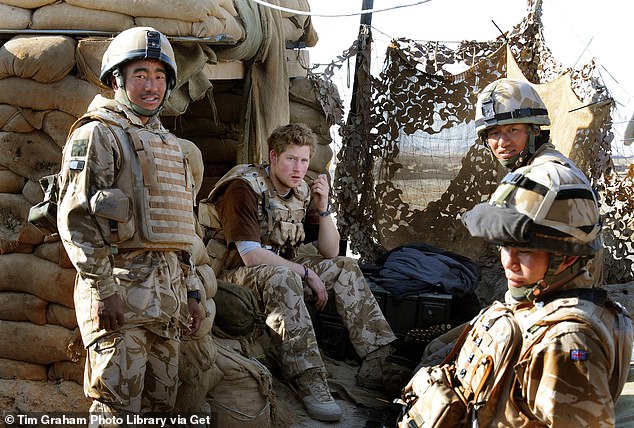 Harry sits with a group of Gurkha soldiers at an observation post on JTAC Hill