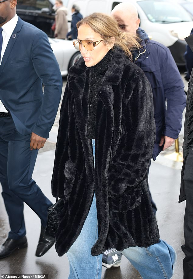 Jennifer Lopez wrapped in a long black fur coat as she returned to her hotel on Tuesday after a day of shopping during Paris Fashion Week